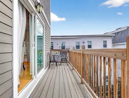 a view of a balcony with wooden floor and fence