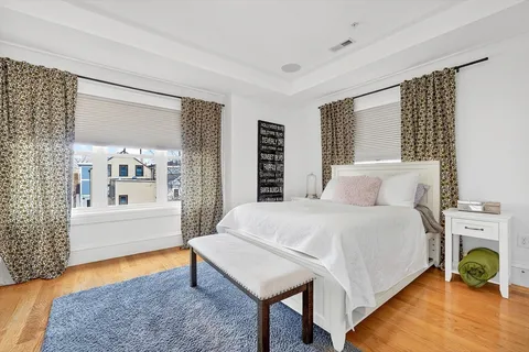 a bedroom with a bed a bookshelf and a window