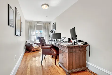 a view of a workspace with furniture and wooden floor