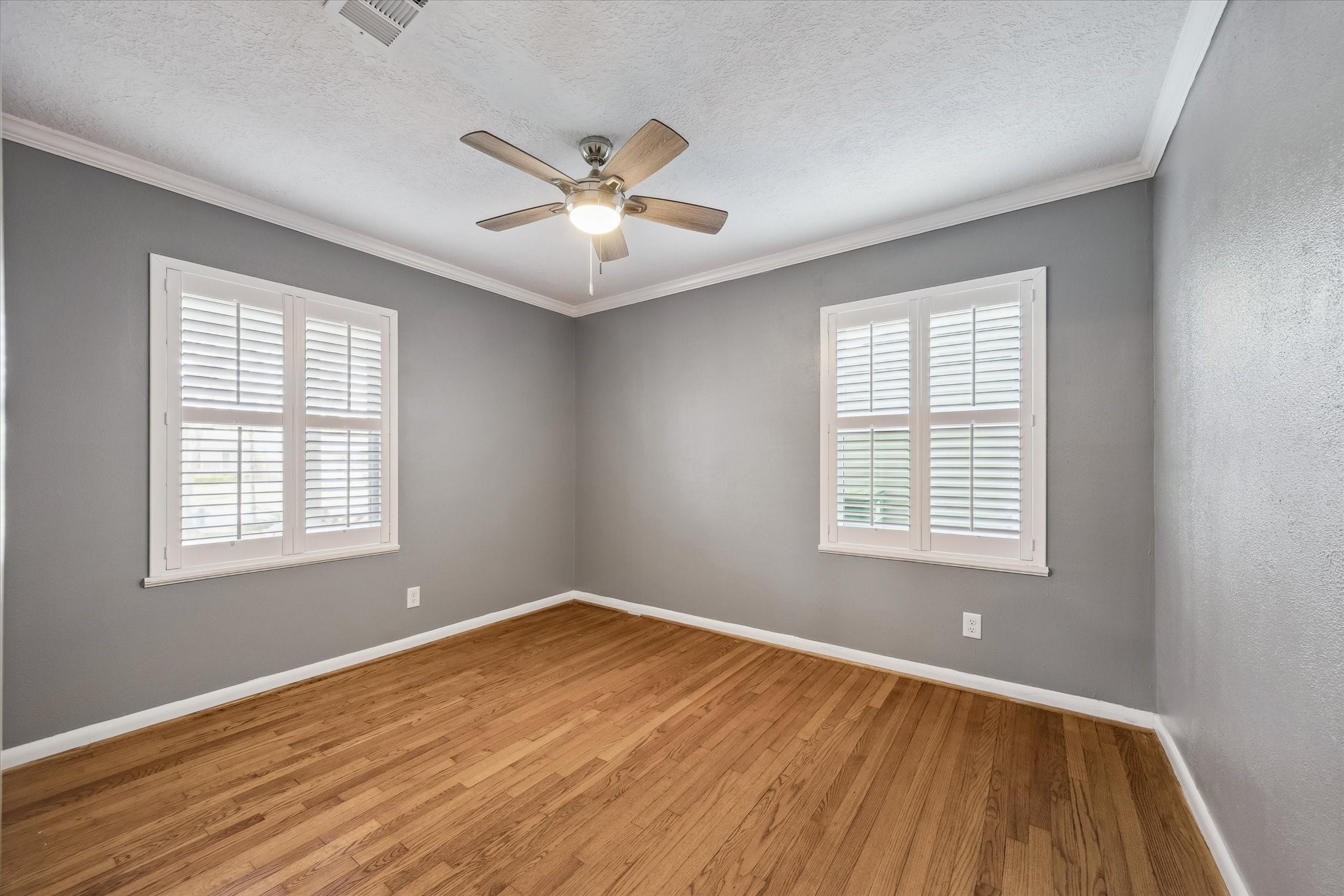 1423 Richelieu Lane Houston, TX 77018 - Photo 18 of 46 a view of an empty room with wooden floor and a window
