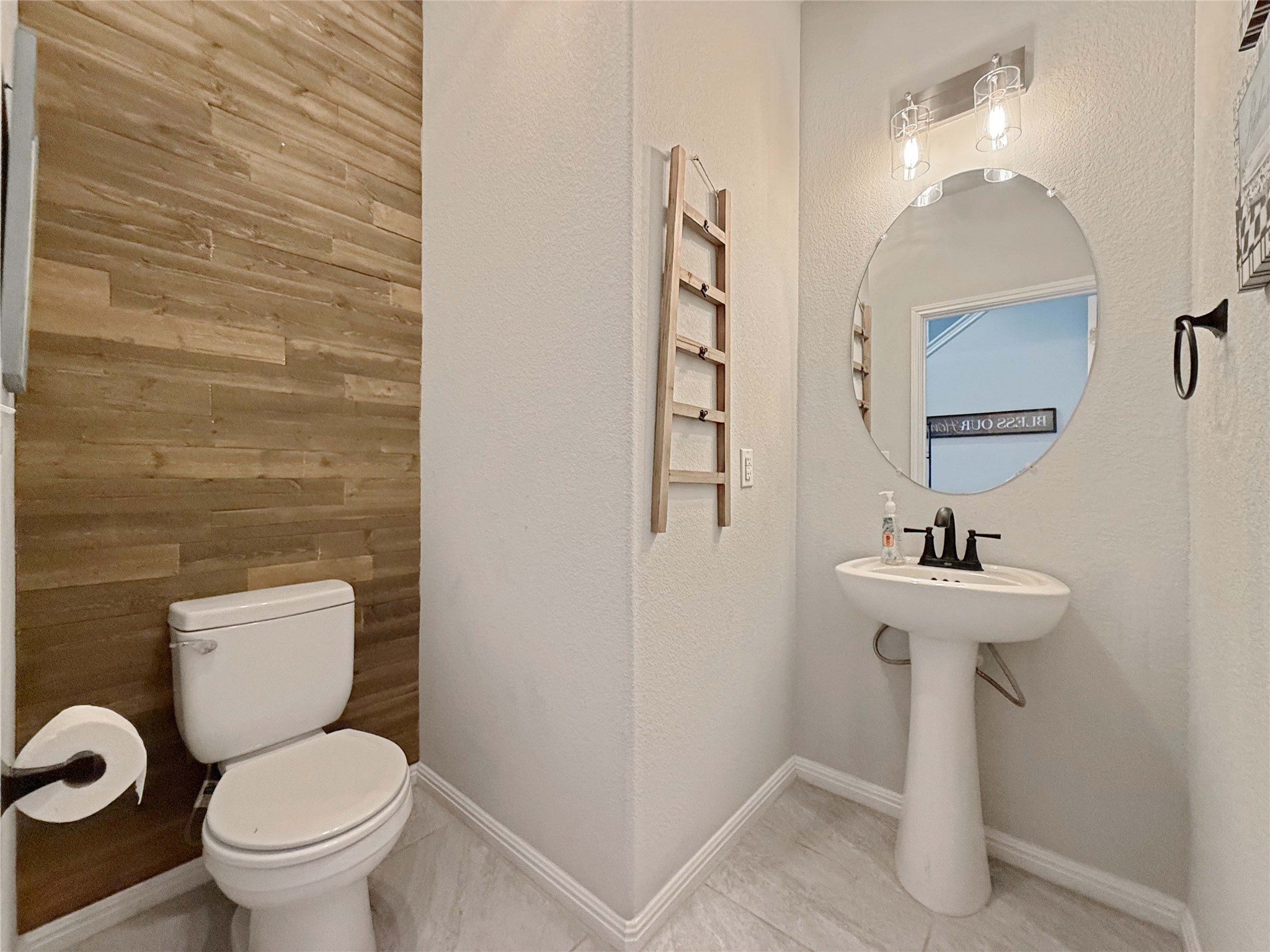 429 Rusk Bluff Avenue Leander, TX 78641 - Photo 12 of 24 A well-appointed powder room features stylish wood accent wall and modern pedestal sink.