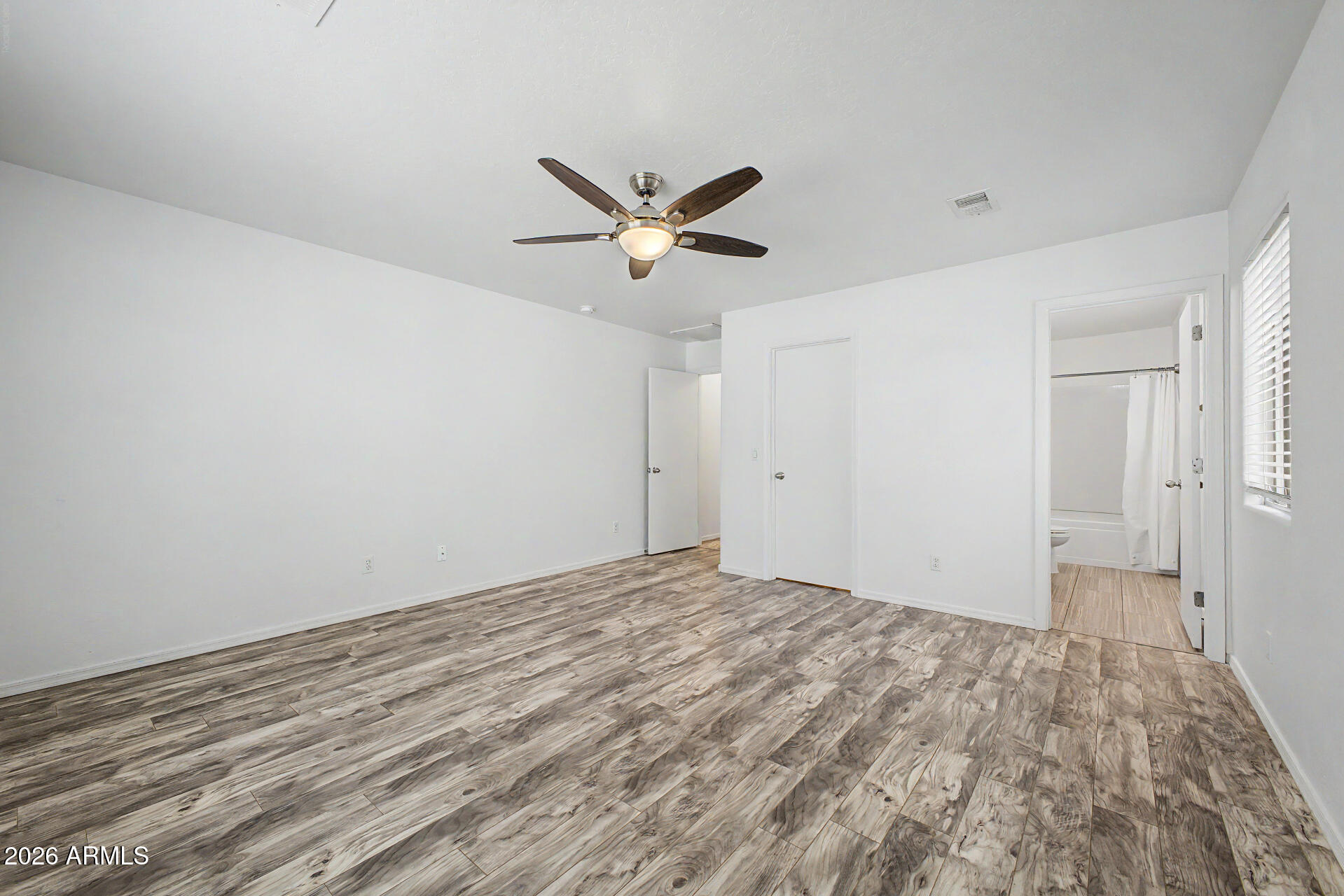 1882 West Rd Agent Street Apache Junction, AZ 85120 - Photo 11 of 26 a view of a big room with wooden floor and a ceiling fan