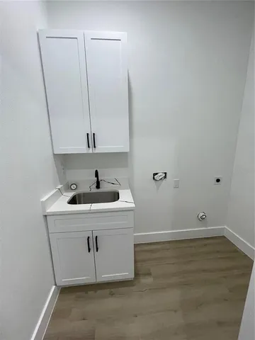 a view of a hallway with wooden floor and a living room