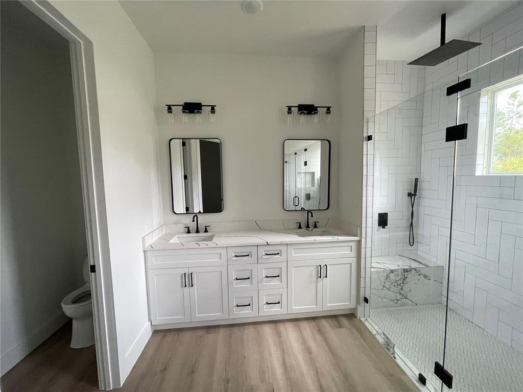 41719 Aspen Street Eustis, FL 32736 - Photo 38 of 52 a spacious bathroom with a double vanity sink a mirror and a bathtub