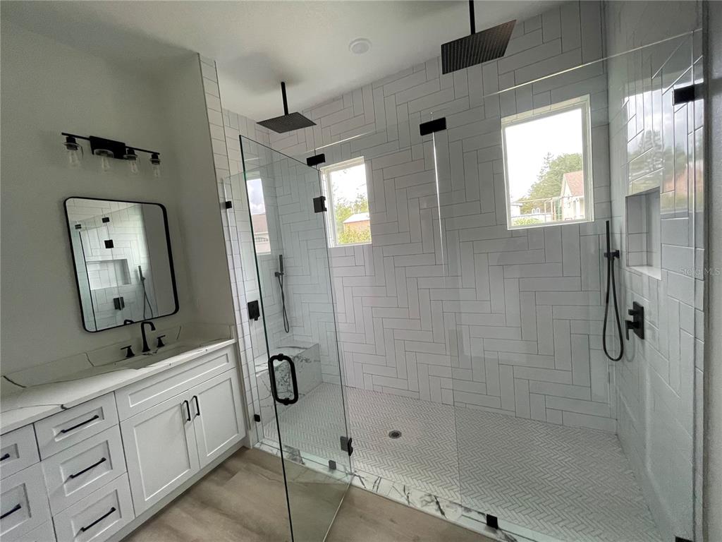 41719 Aspen Street Eustis, FL 32736 - Photo 39 of 52 a bathroom with a double vanity sink a mirror and a shower