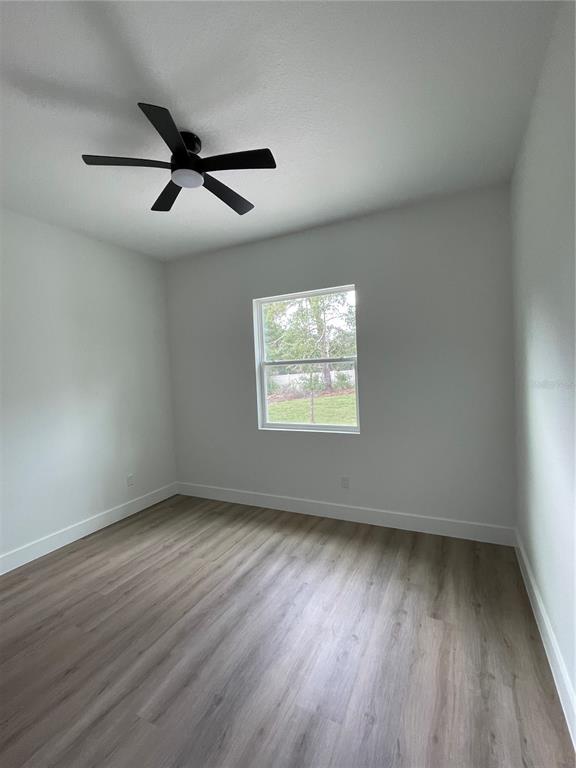 41719 Aspen Street Eustis, FL 32736 - Photo 47 of 52 an empty room with wooden floor and windows
