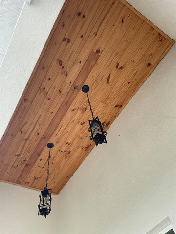 a view of an empty room with wooden floor and fan