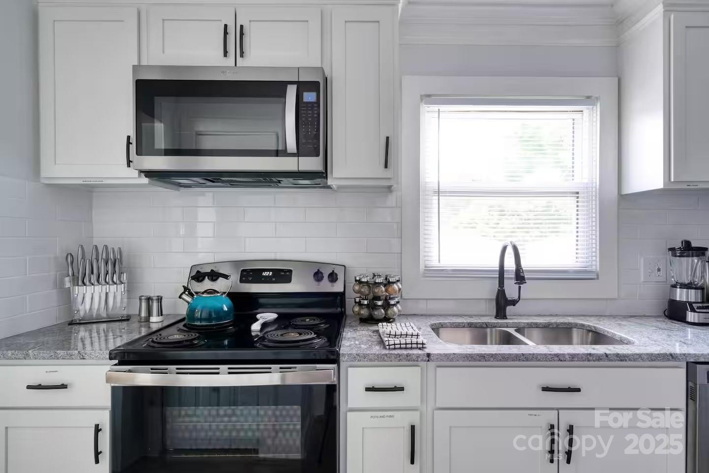 3337 Washburn Avenue Charlotte, NC 28205 - Photo 17 of 23 a kitchen with stainless steel appliances granite countertop a sink a stove a microwave a counter space and cabinets