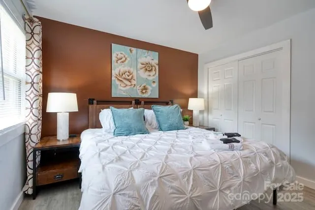 a bedroom with a bed and a lamp on dresser