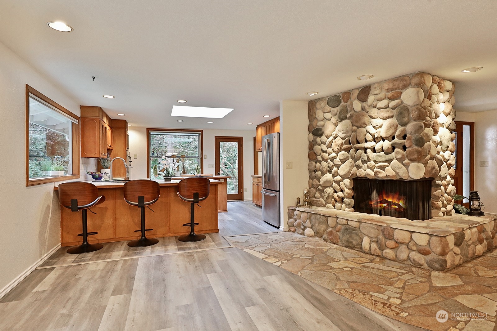 5003 East Harbor Road Freeland, WA 98249 - Photo 13 of 40 a living room with furniture a fireplace and a floor to ceiling window