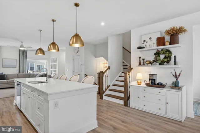 a kitchen with stainless steel appliances granite countertop a refrigerator a stove a kitchen island a dining table and chairs