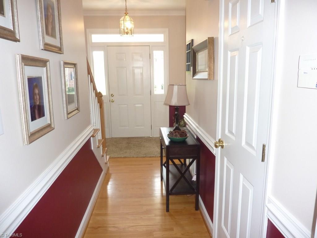 6325 Armsby Road Clemmons, NC 27012 - Photo 3 of 30 Foyer with transom and glass side paneling, light fixture, hardwoods, chair rail, and hardwood stairs lead to the upper level.
