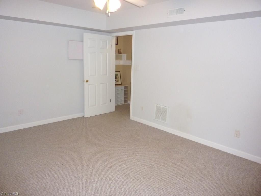6325 Armsby Road Clemmons, NC 27012 - Photo 24 of 30 Lower level room with a ceiling fan and neutral decor .... could be used for exercising, an office, or even a home theater.