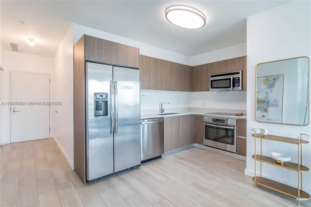 a kitchen with granite countertop a refrigerator and a stove top oven