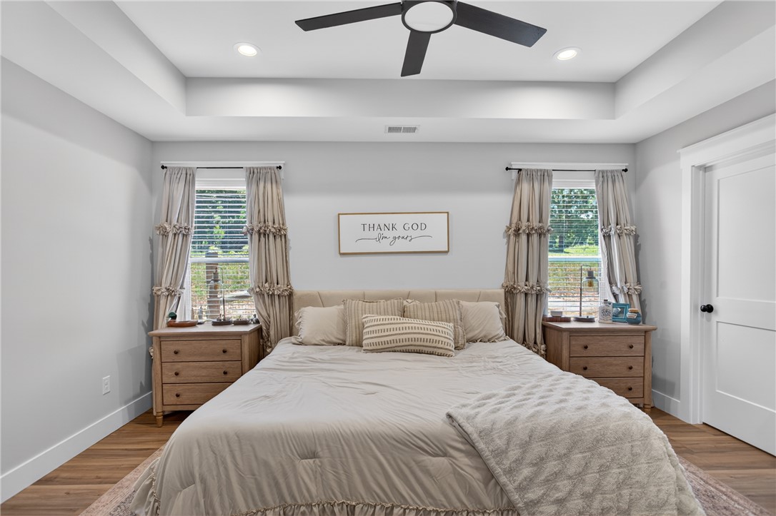 106 Bolt Road Townville, SC 29689 - Photo 14 of 33 A comforting primary bedroom with a tray ceiling and wood flooring provides a serene retreat.