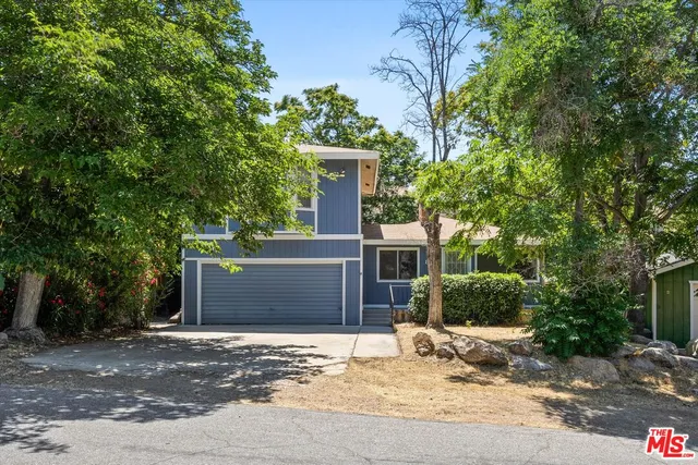 a view of a house with a tree and plants