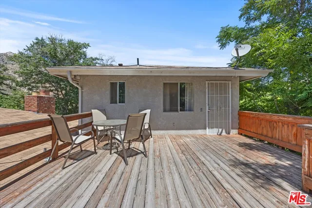 a view of a patio with table and chairs with wooden floor and fence