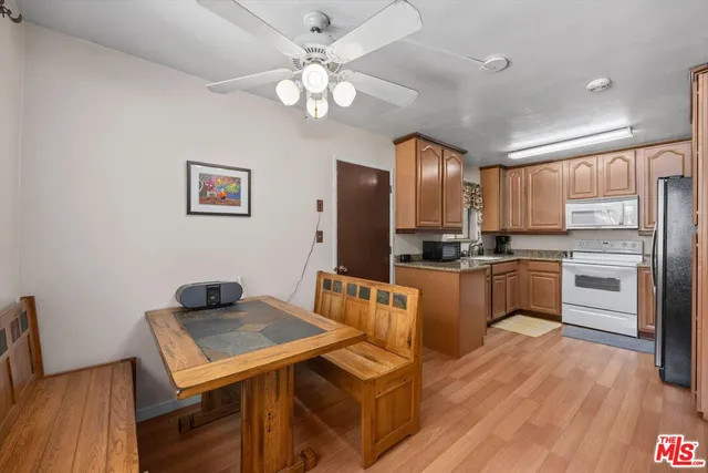 a kitchen with a refrigerator a stove top oven a sink dishwasher and wooden floor