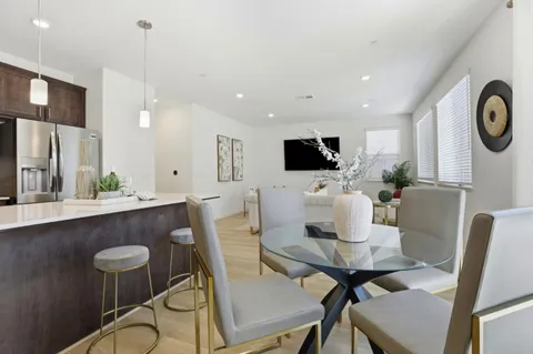 a kitchen with a dining table chairs refrigerator and cabinets