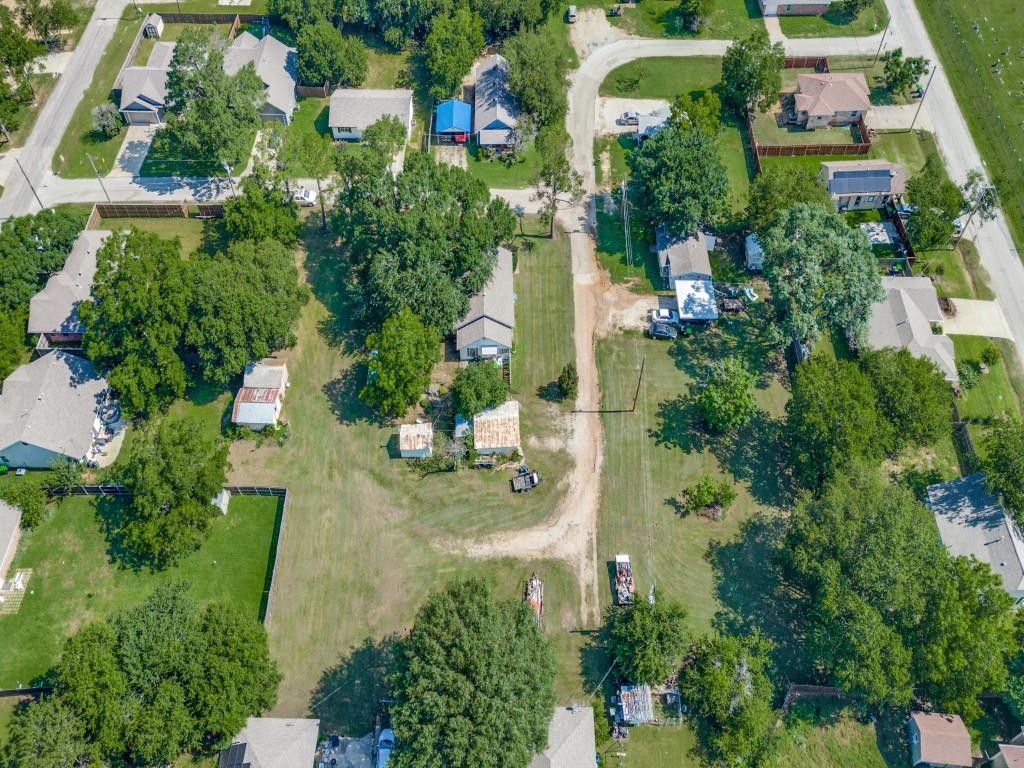 an aerial view of residential houses with outdoor space and trees