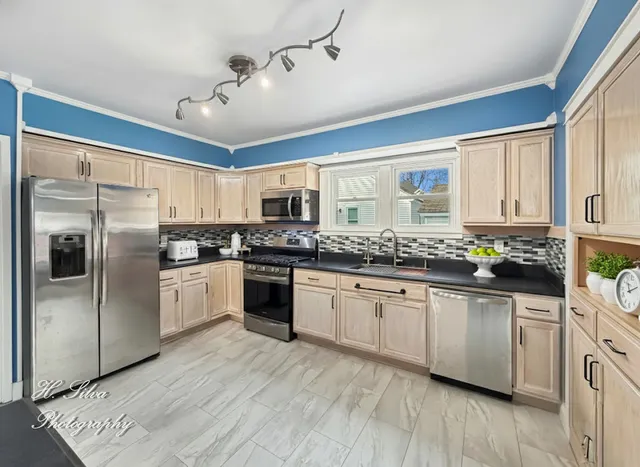 a kitchen with stainless steel appliances a refrigerator sink and cabinets