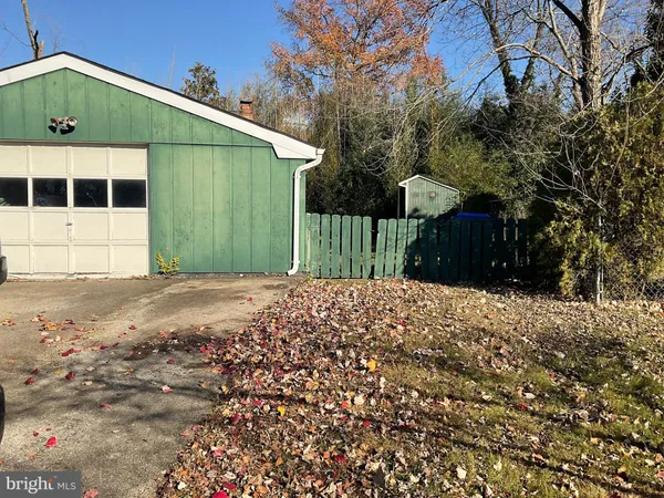 a view of a house with a yard and large trees