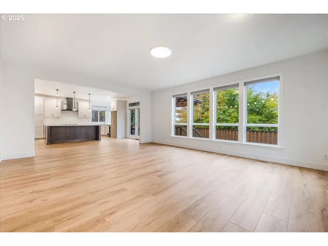 a view of a living room a kitchen with wooden floor and windows
