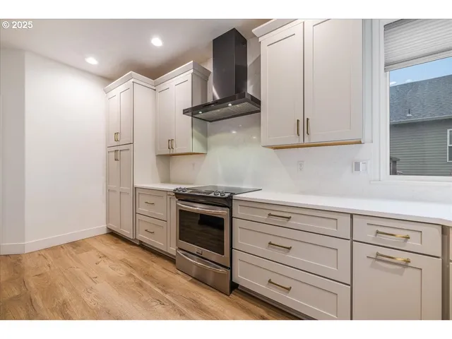a kitchen with stainless steel appliances granite countertop a sink a stove and a refrigerator