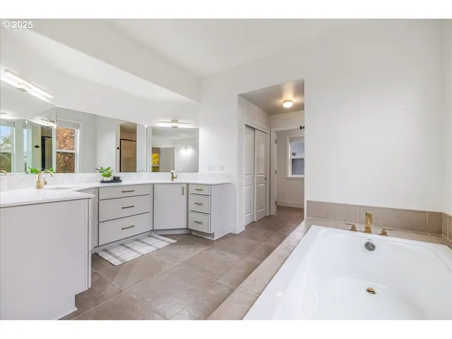 a bathroom with a tub sink and mirror