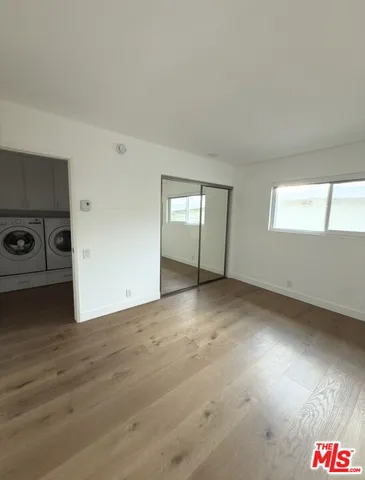 an empty room with windows and cabinet