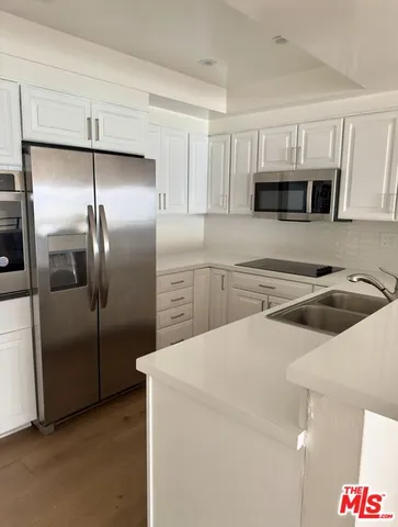 a kitchen with stainless steel appliances a refrigerator sink and microwave
