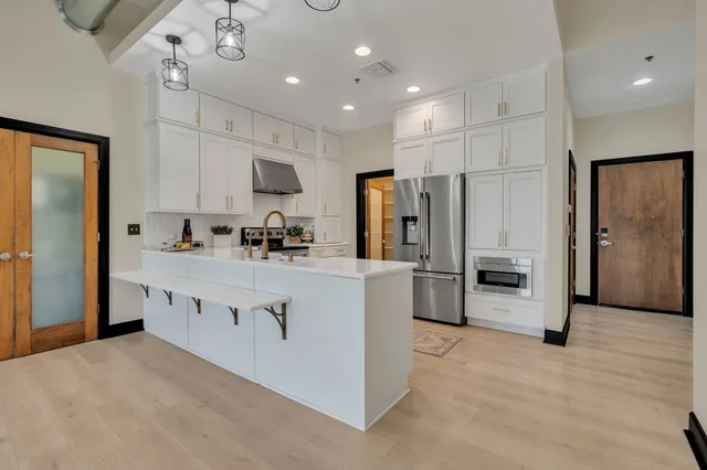 a kitchen with stainless steel appliances a refrigerator sink and cabinets