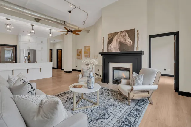 a living room with furniture a fireplace and a chandelier