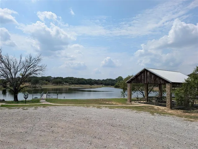 a view of a lake with a big yard and large trees