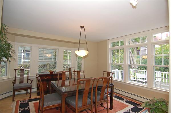 226 Upland Road Cambridge, MA 02140 - Photo 5 of 26 a view of a dining room with furniture large windows and wooden floor
