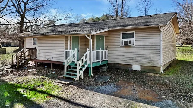 a view of a house with a yard and lawn chairs