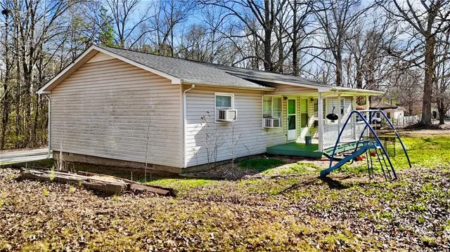 a view of a house with a yard chairs and wooden fence