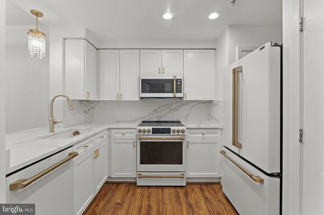 a view of a hallway with wooden floor and a bathroom