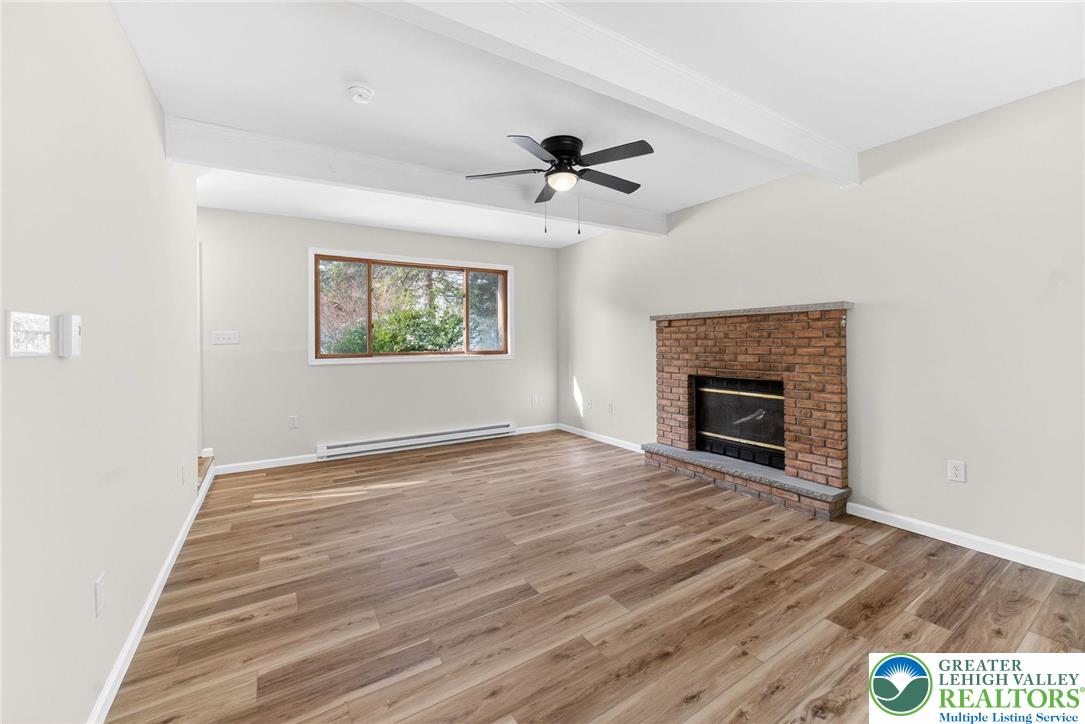 4127 Indian Avenue Pocono Summit, PA 18346 - Photo 6 of 41 an empty room with windows fireplace and wooden floor