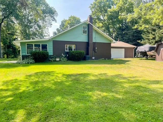 a front view of house with yard and trees in the background