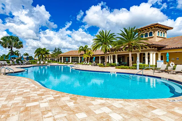 a front view of a house with palm trees and a yard