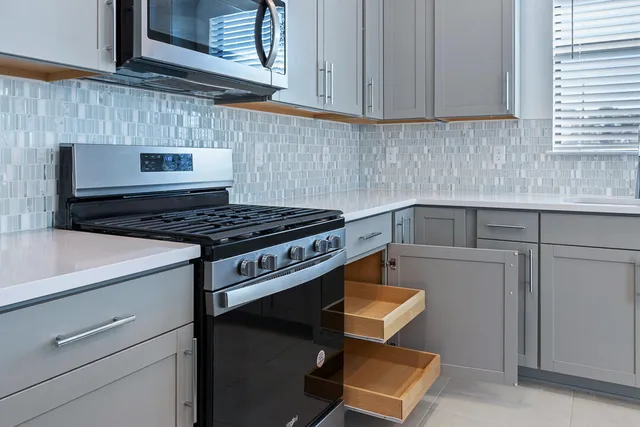a view of a kitchen with a sink and dishwasher a refrigerator with wooden floor
