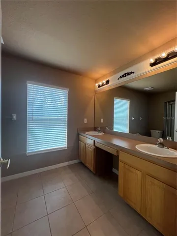 a bathroom with a granite countertop sink mirror and a bathtub