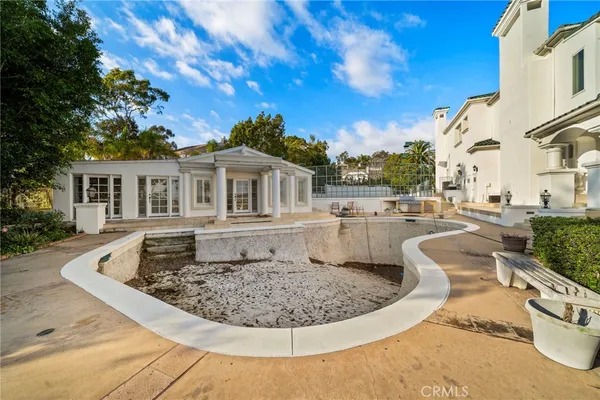 a front view of a house with swimming pool and sitting area