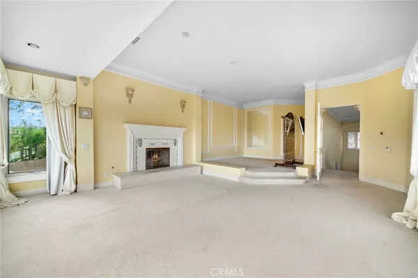 a view of an empty room with a fireplace and a window