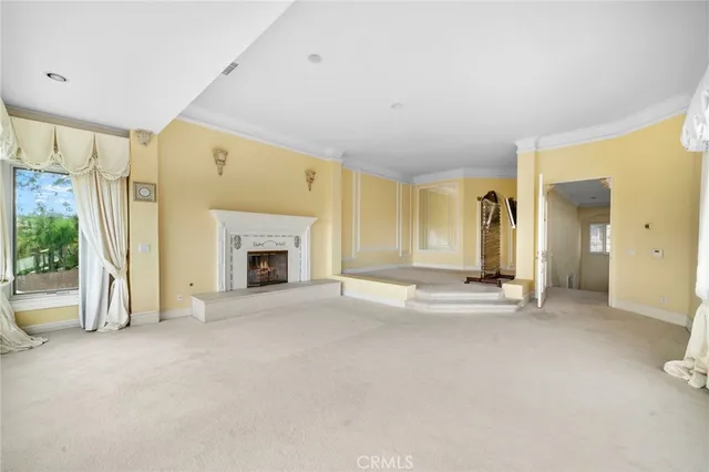 a view of an empty room with a fireplace and a window