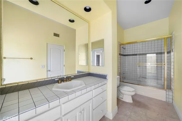 a bathroom with a granite countertop double vanity sink and a mirror
