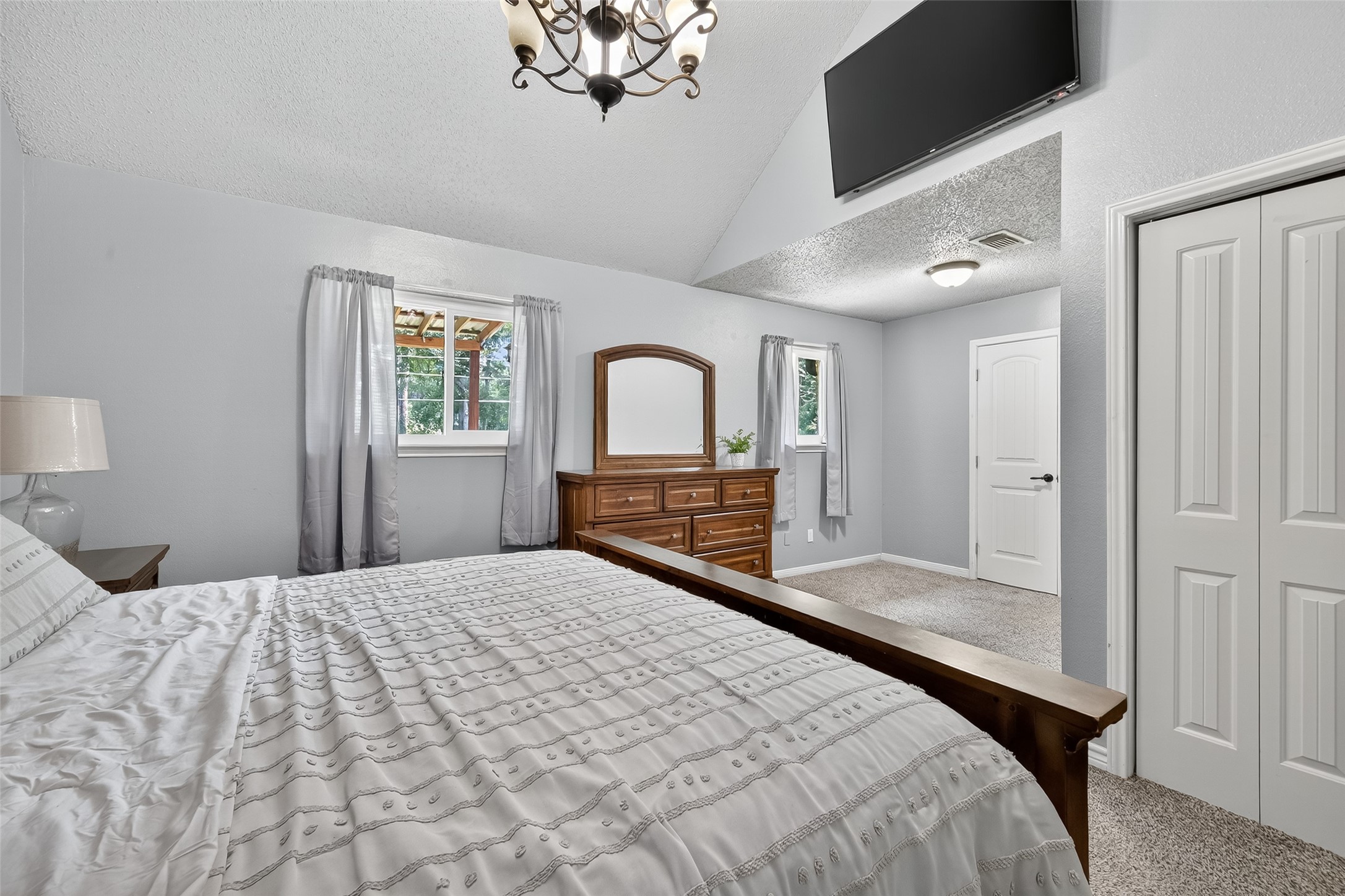 2103 Diane Street Pinehurst, TX 77362 - Photo 11 of 17 a bedroom with a large bed and a chandelier