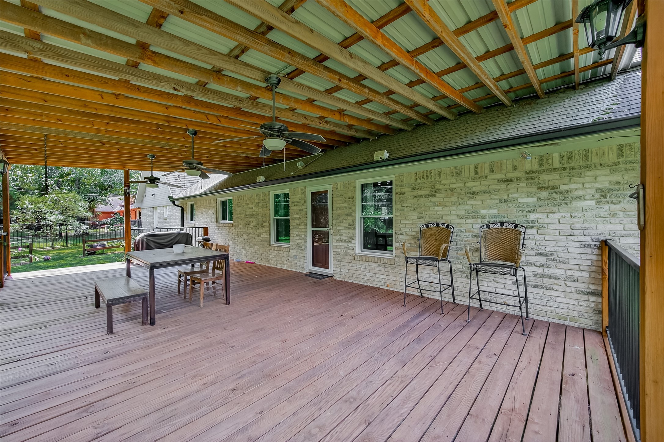 2103 Diane Street Pinehurst, TX 77362 - Photo 16 of 17 a view of a patio with table and chairs a barbeque with wooden floor and fence with barbeque grill