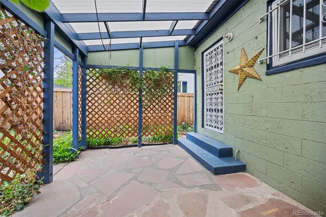 a house with a bench and potted plants